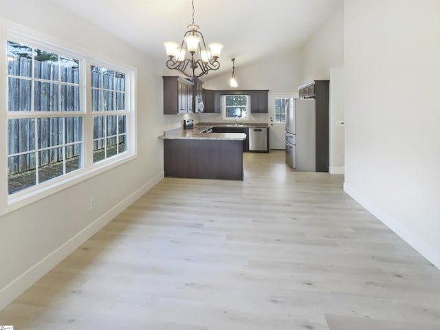 10 Maplecroft St, Greenville, SC 29609 - kitchen with light wood-style flooring, a notable chandelier, a peninsula, light countertops, and appliances with stainless steel finishes