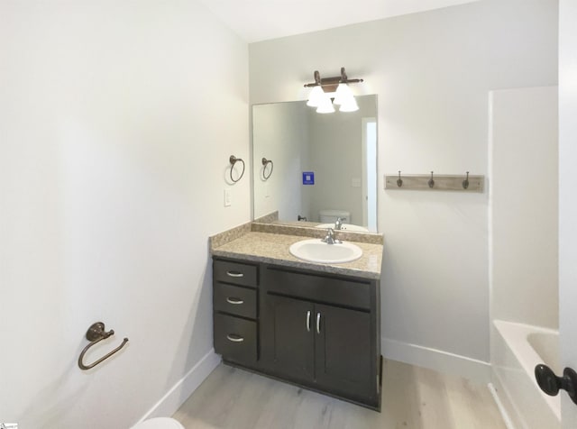 10 Maplecroft St, Greenville, SC 29609 - bathroom with baseboards, vanity, toilet, and wood finished floors
