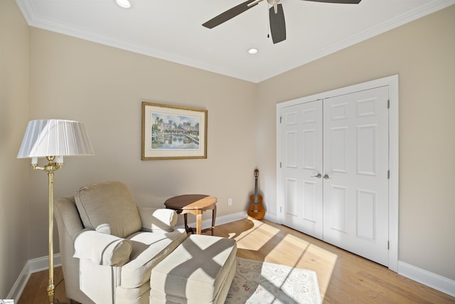 sitting room featuring hardwood / wood-style floors, crown molding, and ceiling fan