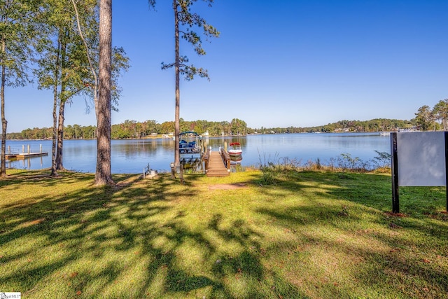 view of dock featuring a lawn and a water view