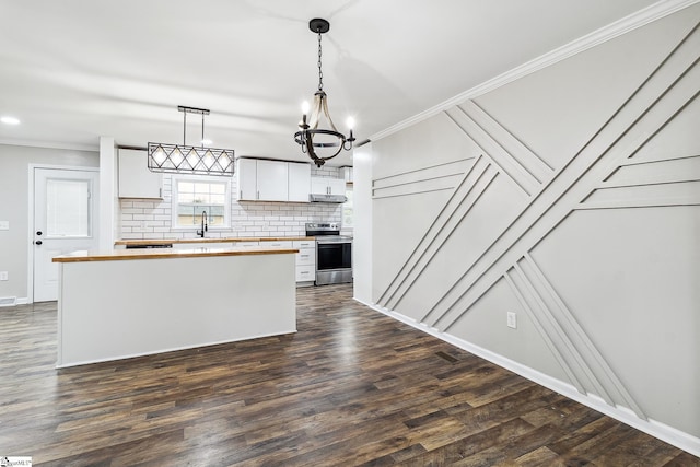 kitchen featuring hanging light fixtures, white cabinets, stainless steel range with electric stovetop, wood counters, and crown molding