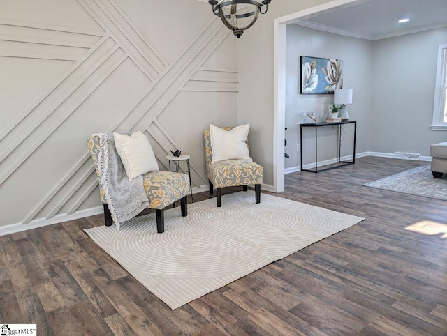 sitting room with a notable chandelier, dark hardwood / wood-style flooring, and ornamental molding