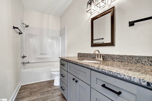 full bathroom featuring toilet, wood-type flooring, vanity, and tub / shower combination