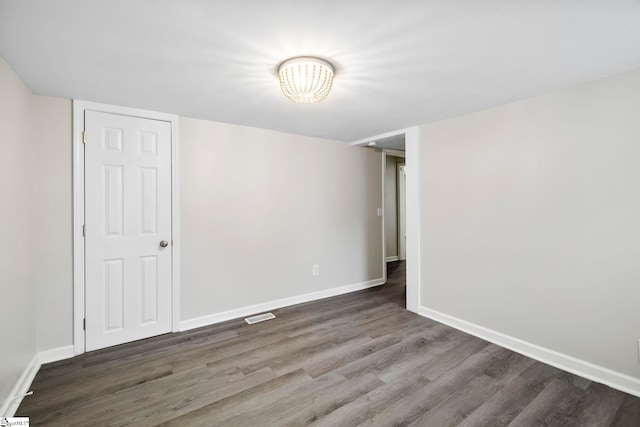 unfurnished room with dark wood-type flooring