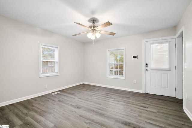 spare room featuring ceiling fan, plenty of natural light, and dark wood-type flooring