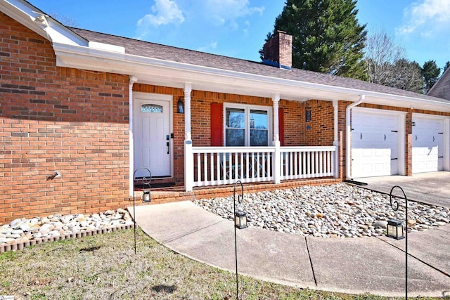 view of exterior entry with a porch and a garage