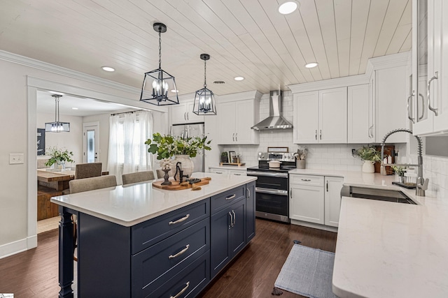 kitchen featuring sink, appliances with stainless steel finishes, white cabinets, and wall chimney exhaust hood