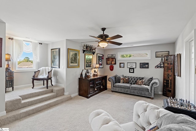 living room featuring light colored carpet, a ceiling fan, and baseboards