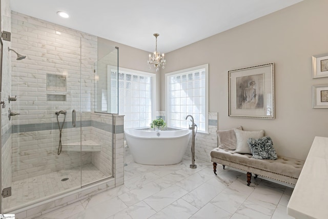 full bathroom featuring a chandelier, a soaking tub, tile walls, marble finish floor, and a stall shower