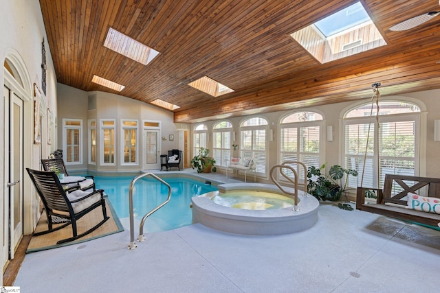 view of pool with a pool with connected hot tub and a skylight