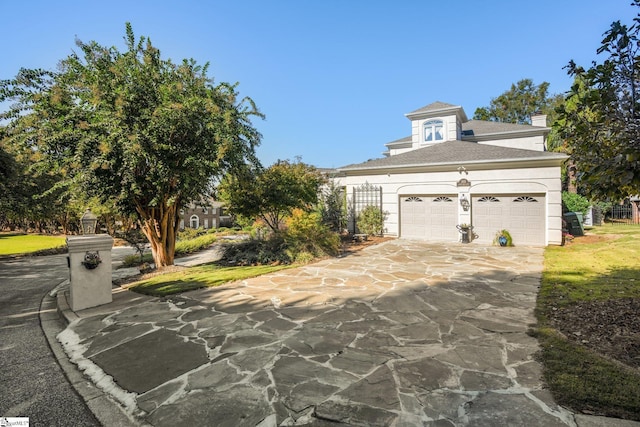 view of front of home with concrete driveway, an attached garage, and stucco siding