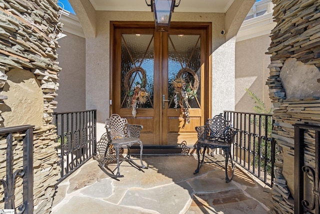 doorway to property with french doors, stucco siding, and a balcony