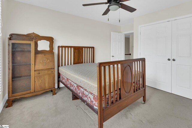 carpeted bedroom featuring a closet and ceiling fan