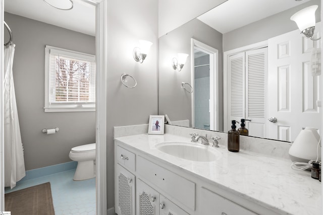 bathroom with toilet, vanity, and tile patterned flooring