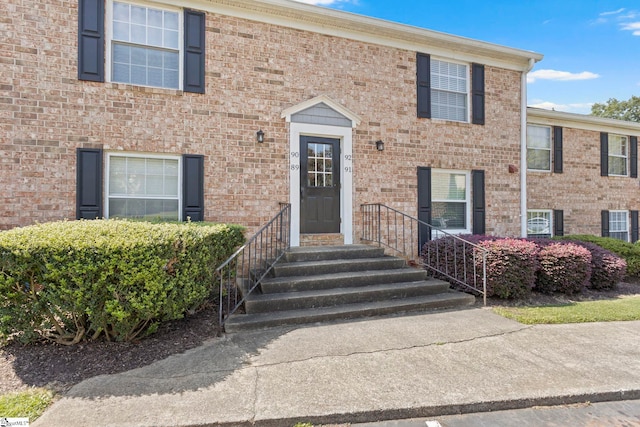 view of front of property with central AC and brick siding