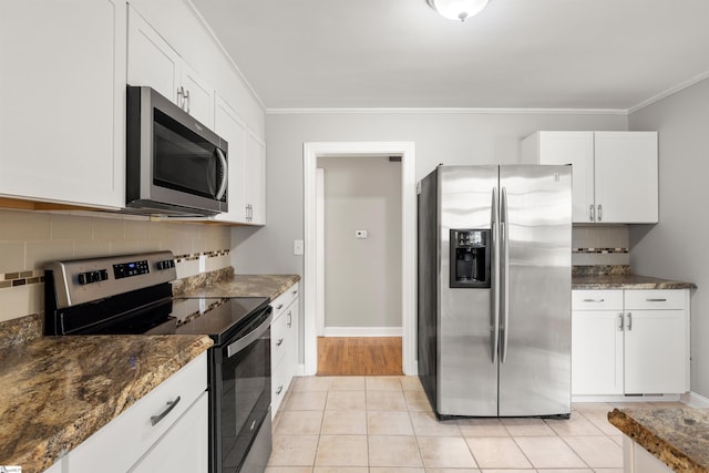 kitchen featuring dark stone countertops, white cabinetry, appliances with stainless steel finishes, and crown molding