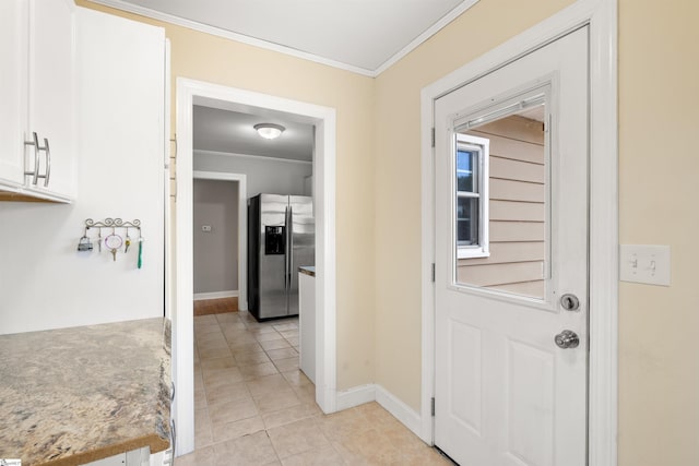 doorway featuring baseboards, light tile patterned floors, and crown molding