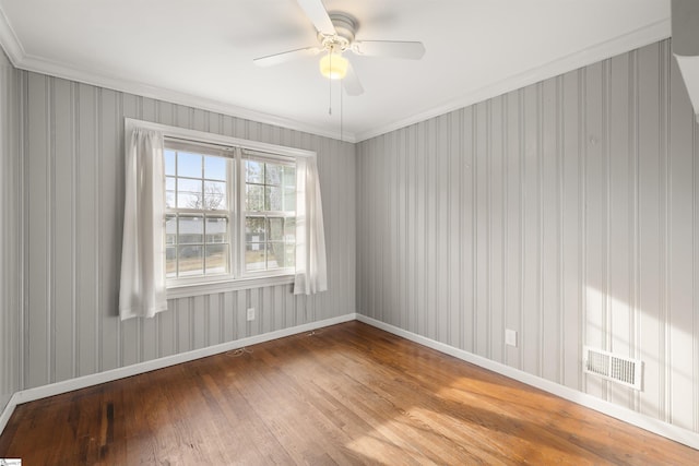 empty room with baseboards, ceiling fan, visible vents, and wood finished floors