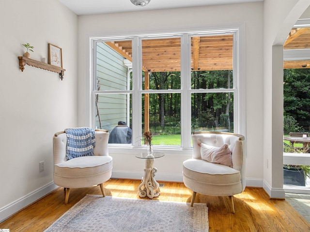 sitting room featuring baseboards and light wood-type flooring