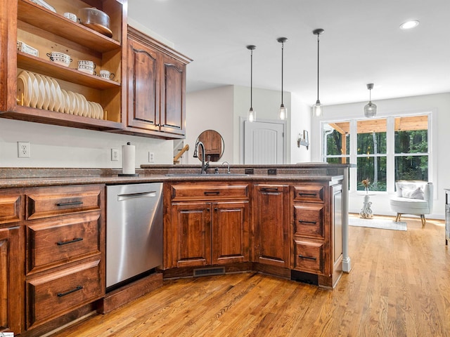 kitchen with visible vents, a sink, pendant lighting, dark countertops, and dishwasher