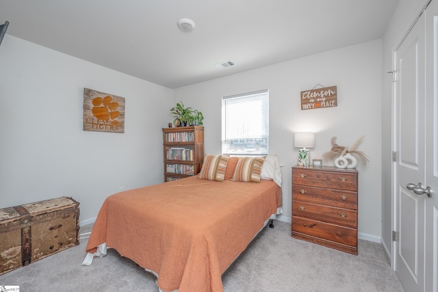 bedroom with baseboards, visible vents, and light colored carpet