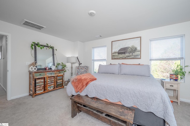 bedroom with visible vents, baseboards, and light colored carpet