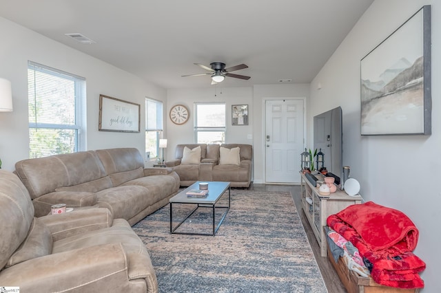 living area featuring ceiling fan, dark wood-style floors, and visible vents