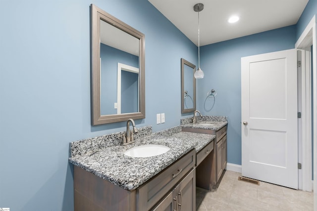 bathroom featuring two vanities, a sink, visible vents, and baseboards