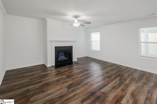 unfurnished living room featuring dark wood-style floors, crown molding, visible vents, a fireplace with flush hearth, and baseboards