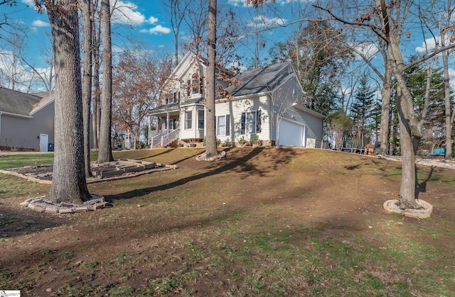 view of front of home featuring an attached garage, a front lawn, and a porch