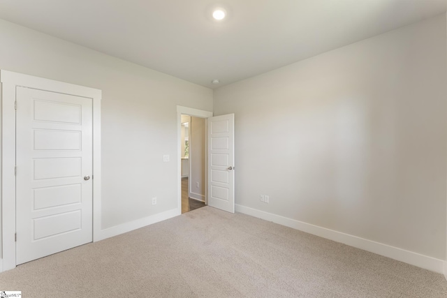 unfurnished bedroom with carpet floors and baseboards