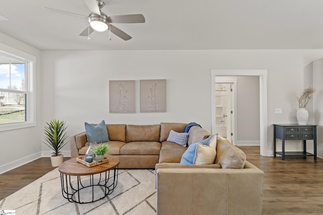 living area with ceiling fan, dark wood-type flooring, and baseboards