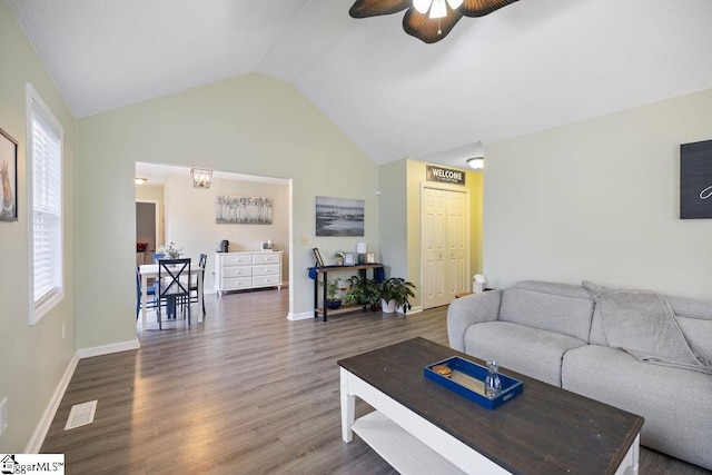 living area with vaulted ceiling, ceiling fan, wood finished floors, and baseboards