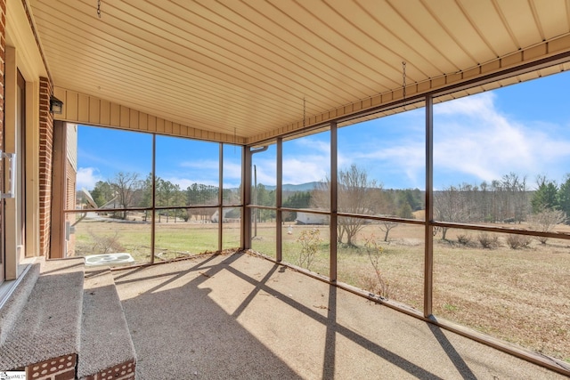 unfurnished sunroom featuring lofted ceiling and a healthy amount of sunlight