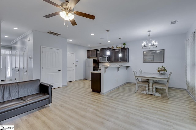 kitchen featuring a peninsula, stainless steel microwave, open floor plan, and light countertops