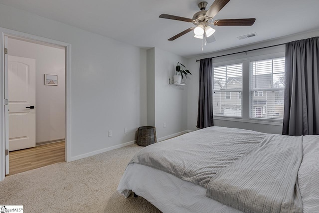 bedroom with visible vents, ceiling fan, light carpet, and baseboards