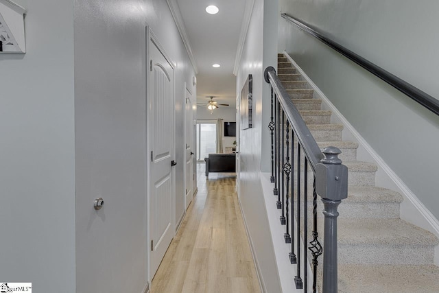 stairway featuring recessed lighting, crown molding, baseboards, and wood finished floors