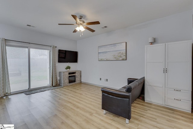 sitting room featuring a ceiling fan, visible vents, light wood-style flooring, and baseboards