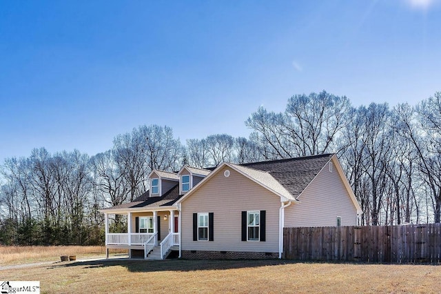 cape cod house featuring covered porch, a front lawn, crawl space, and fence