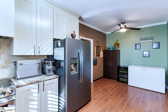 kitchen featuring light stone counters, beverage cooler, white cabinets, appliances with stainless steel finishes, and crown molding