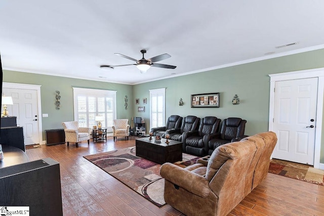 living room featuring a ceiling fan, crown molding, visible vents, and wood finished floors