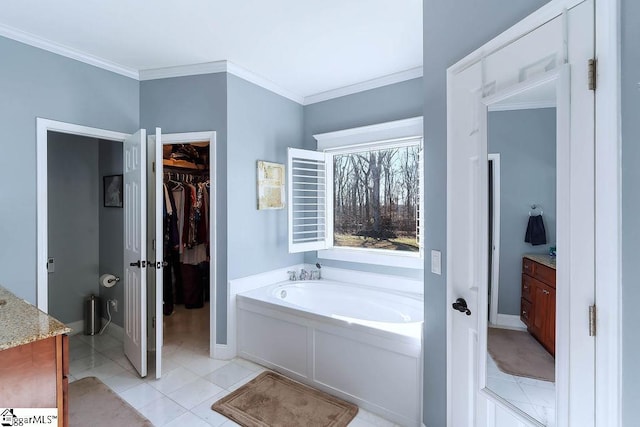 bathroom with tile patterned flooring, a walk in closet, crown molding, vanity, and a bath