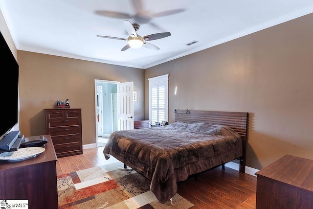 bedroom with light wood-style floors, baseboards, visible vents, and crown molding