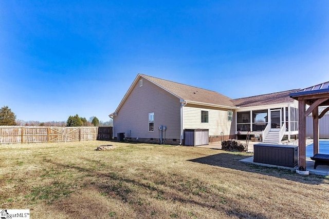 back of house with a sunroom, a fenced backyard, and a lawn