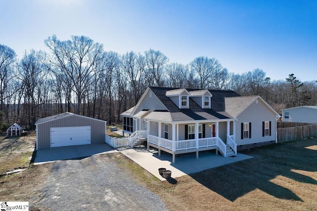 view of front of property with roof with shingles, a detached garage, a porch, and an outdoor structure