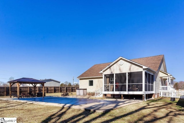 back of house with a gazebo, a yard, a patio, and a sunroom