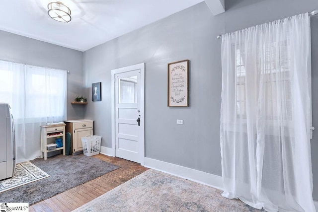 entryway with dark wood finished floors and baseboards