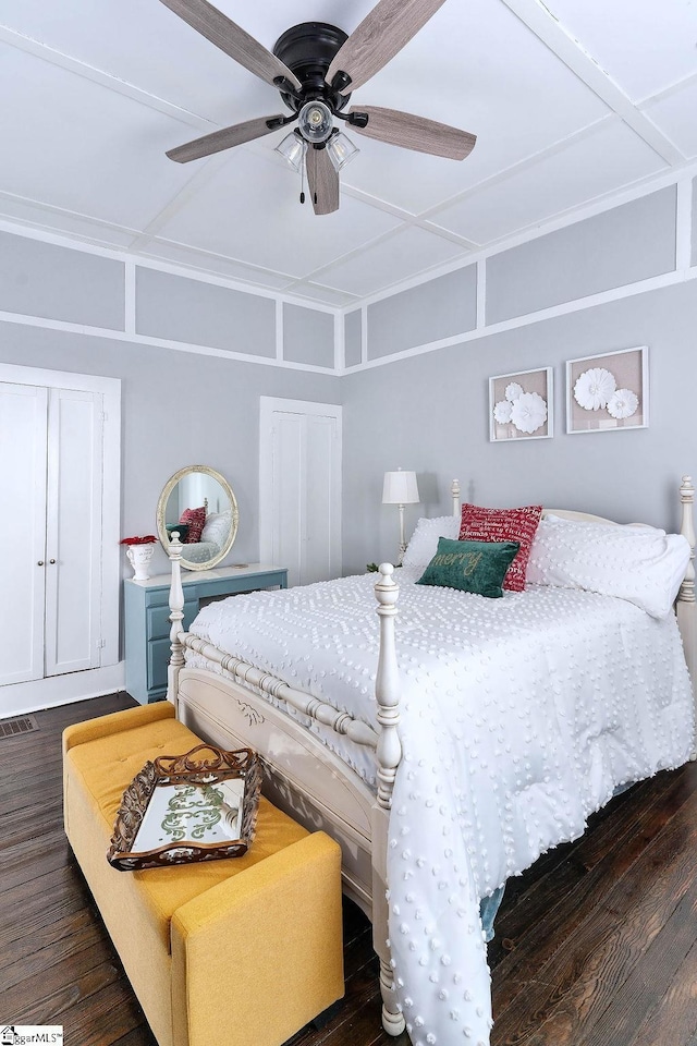 bedroom with visible vents, dark wood-type flooring, and a ceiling fan