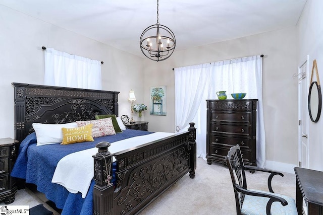 bedroom with a chandelier, baseboards, and light colored carpet