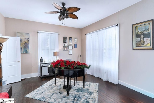 dining room with a ceiling fan, dark wood finished floors, and baseboards